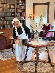 Maid dusting at Bryant House Museum